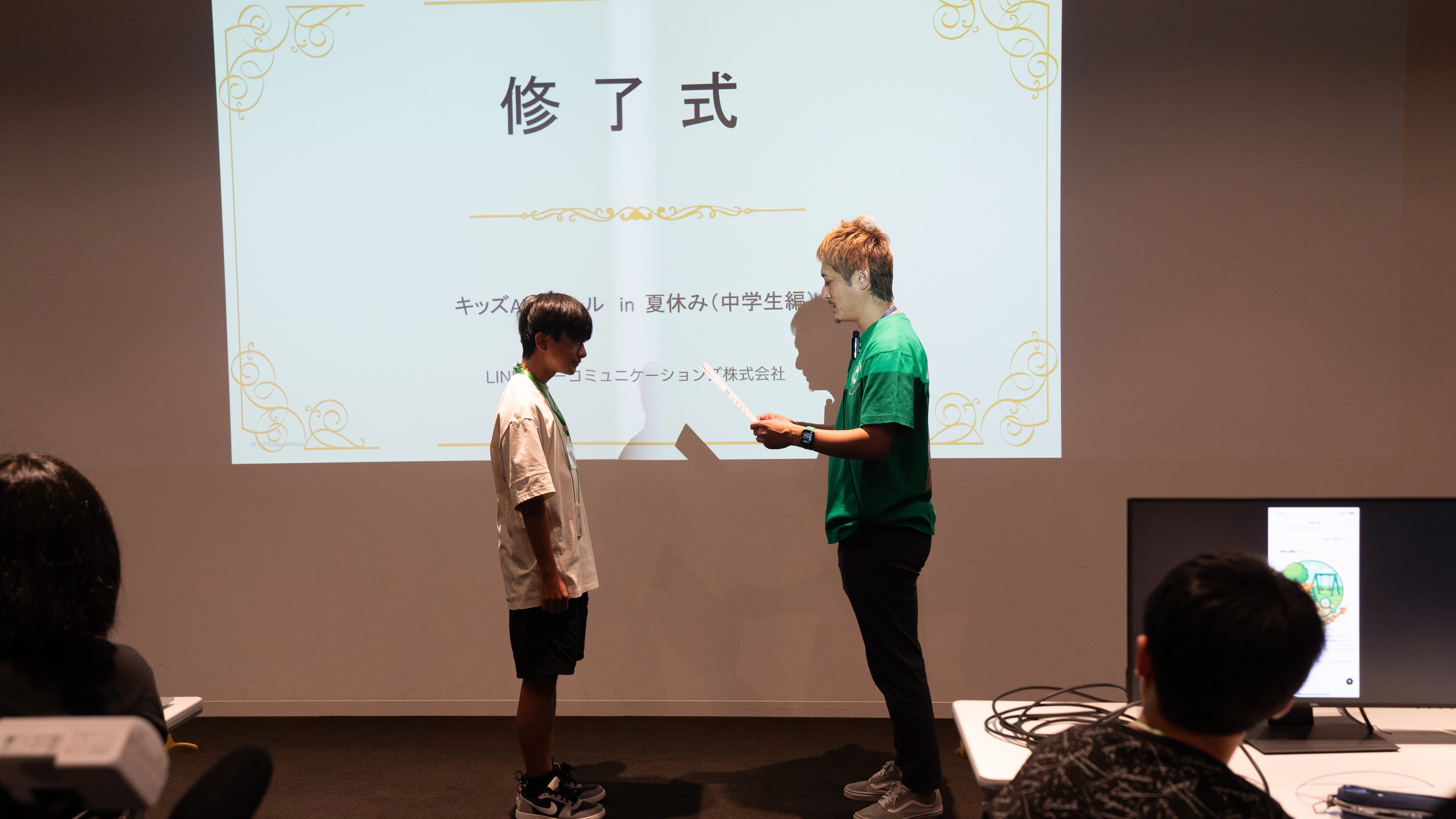 学生が修了証賞を受け取る